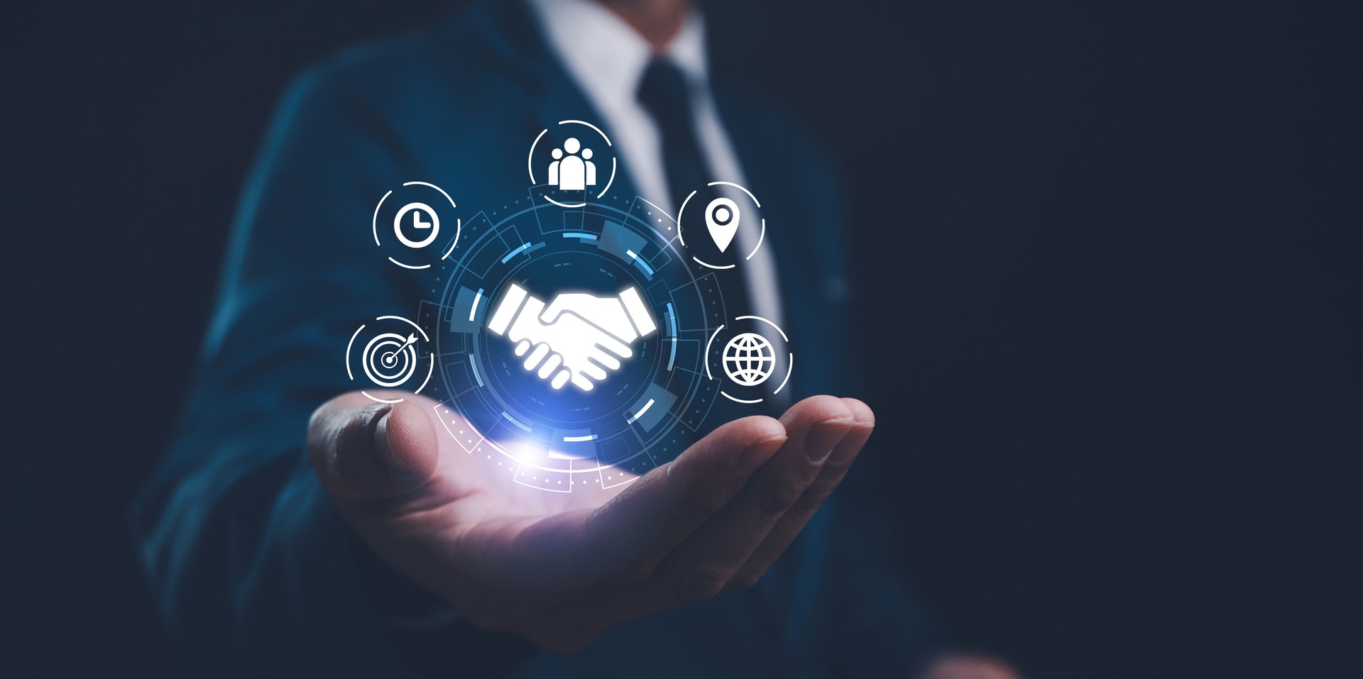 A businessman presents a holographic global partnership concept, with interconnected icons floating above his hand. Business partnerships concept. Business collaboration strategies. A businessman presents a holographic global partnership concept, with interconnected icons floating above his hand. Business partnerships concept. Business collaboration strategies.